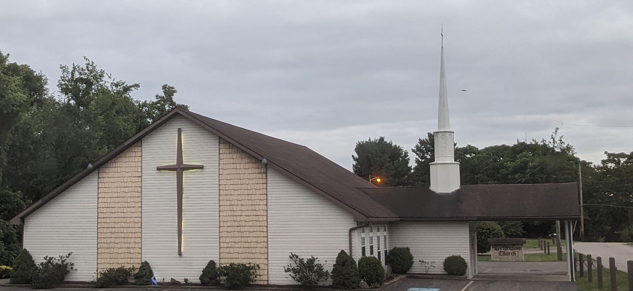 A church with a steeple and cross on the roof.