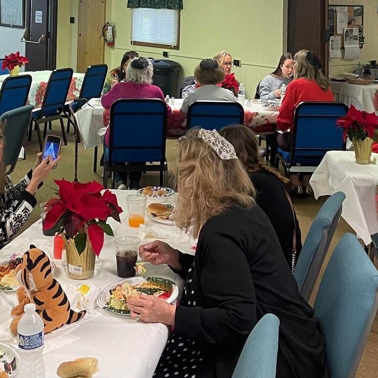 A group of people sitting at tables eating food.